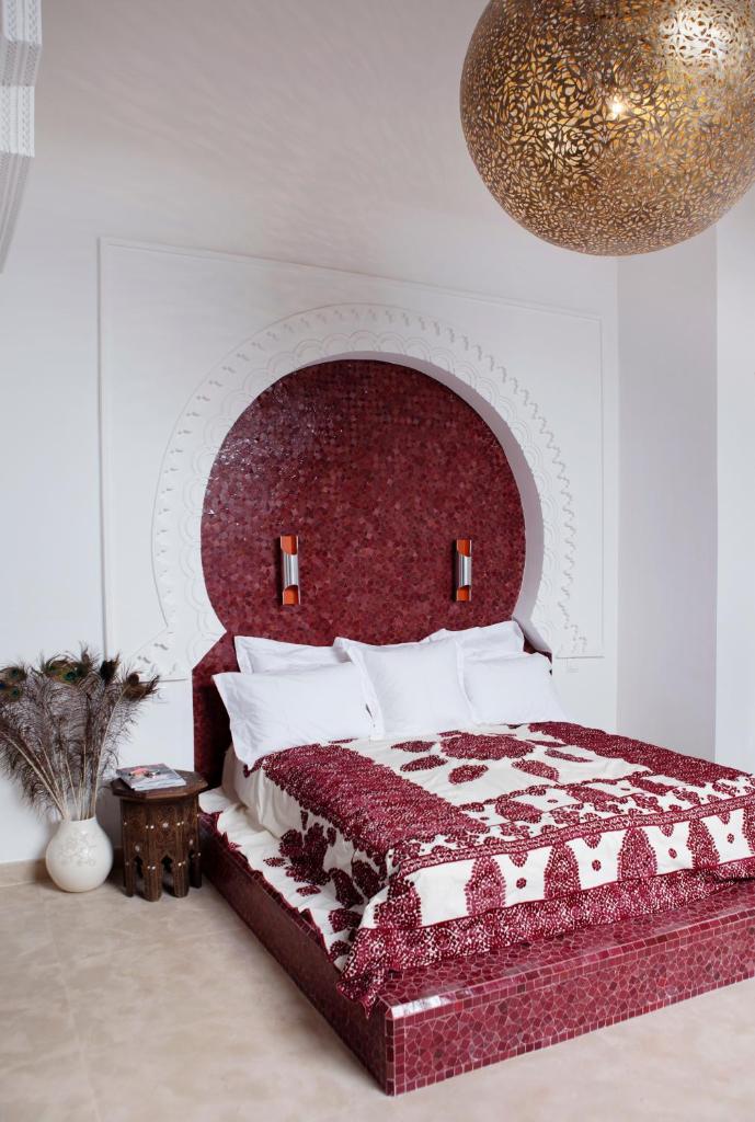 - une chambre avec un lit doté d'une tête de lit rouge dans l'établissement P´tit Habibi, à Marrakech