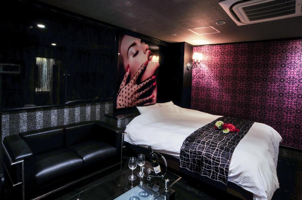 une chambre avec un lit, un canapé et un lavabo dans l'établissement Hotel Grande (Love Hotel), à Kitakyūshū