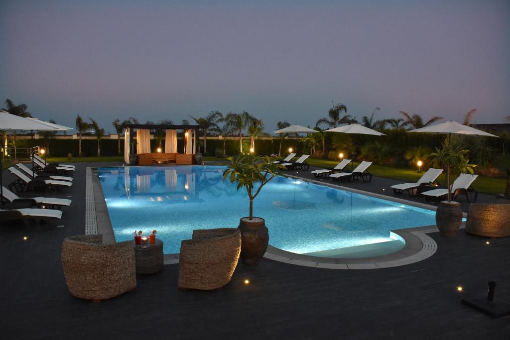 une grande piscine avec des chaises et un complexe dans l'établissement Villa Fenice, à Calatabiano