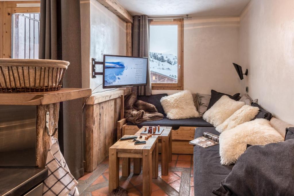 un salon avec un canapé et une télévision dans l'établissement Agate, à Mâcot La Plagne