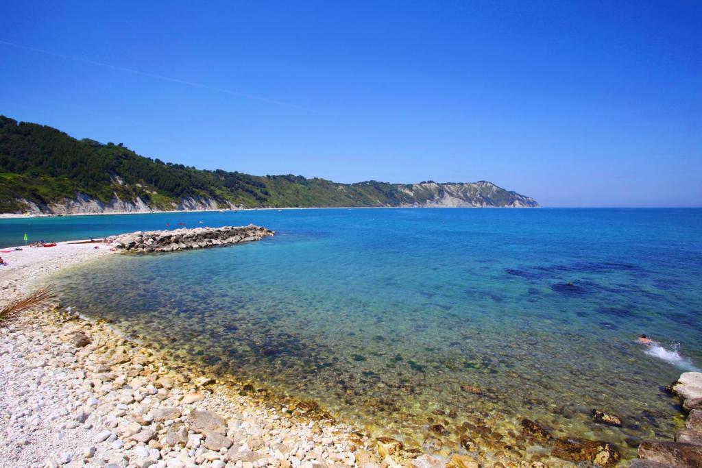 - une vue sur la plage avec des rochers et l'eau dans l'établissement Fortino Napoleonico, à Ancône