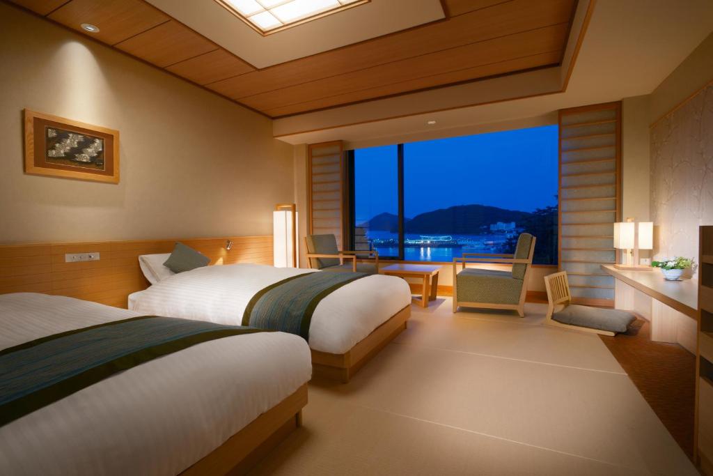- une chambre avec 2 lits et une vue sur l'eau dans l'établissement Toba International Hotel Shiojitei, à Toba