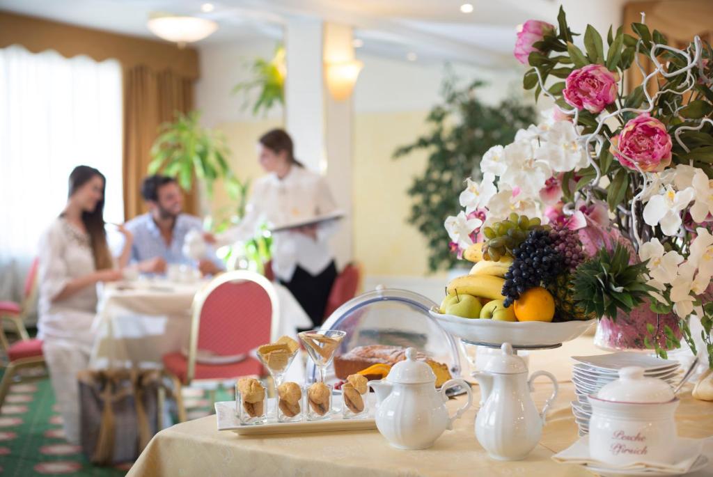 une table recouverte d'une assiette de fruits et de fleurs dans l'établissement Hotel De Londres, à Rimini 101 autres photos