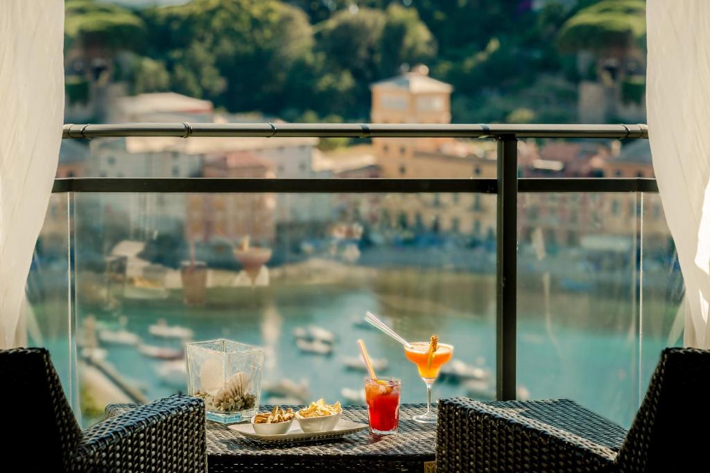 - une table avec de la nourriture et des boissons sur un balcon donnant sur le port dans l'établissement Hotel Vis à Vis, à Sestri Levante