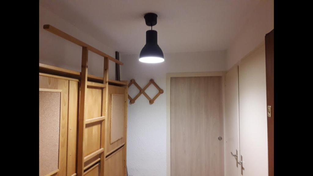 Cette chambre dispose d'un couloir avec une porte et une lumière. dans l'établissement Résidence le Plein Sud, à Les Deux Alpes