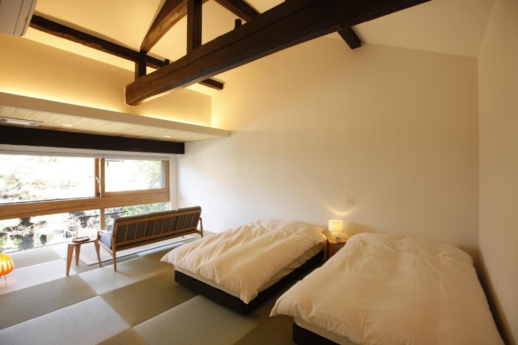 une chambre avec deux lits et une fenêtre dans l'établissement Yamagata The Takinami, à Nanyo