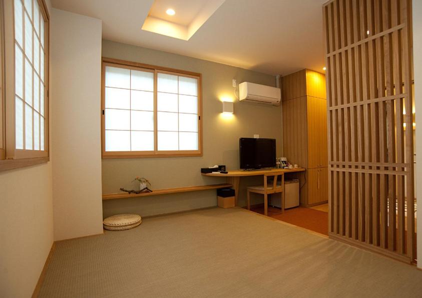 une pièce avec un bureau avec un ordinateur et une fenêtre dans l'établissement Mizuhasou, à Miyajima