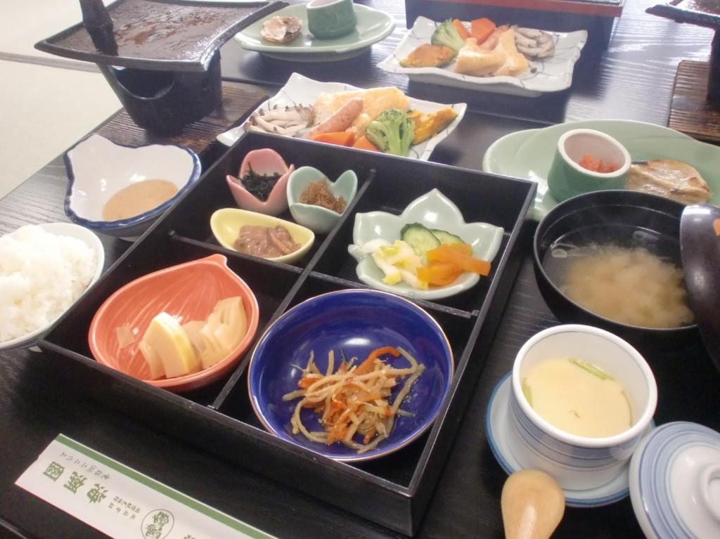 une table recouverte de bols de différents types de denrées alimentaires dans l'établissement Kaichoen, à Yonago