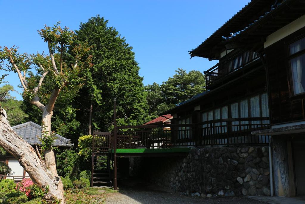 un bâtiment avec un banc vert devant lui dans l'établissement Kougetsu Sanso -- Moon Villa in Tokyo, à Hachioji