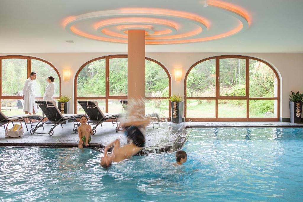 un groupe de personnes jouant dans une piscine dans l'établissement Hotel Weihrerhof, à Soprabolzano