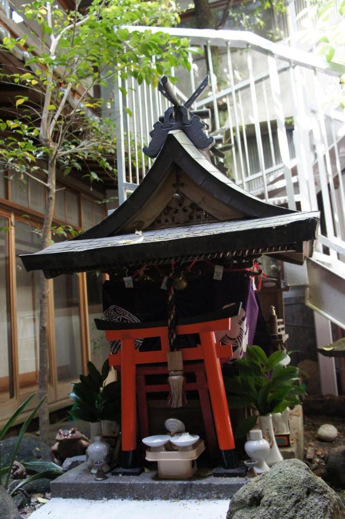 un petit sanctuaire devant un bâtiment dans l'établissement Miyoshiya Ryokan, à Tanabe