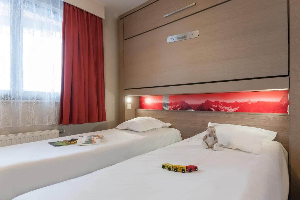 - 2 lits dans une chambre d'hôtel avec un train de jouets dans l'établissement Résidence Pierre & Vacances Atria-Crozats, à Avoriaz