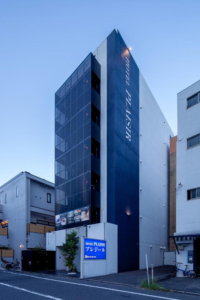un bâtiment avec une enseigne devant lui dans l'établissement Hotel PLAISIR (Adult Only), à Hiroshima