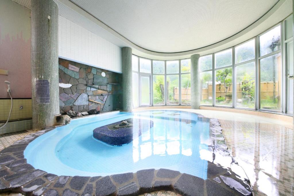 - une piscine dans une maison dotée d'une grande chambre avec fenêtres dans l'établissement Micasa, à Minakami
