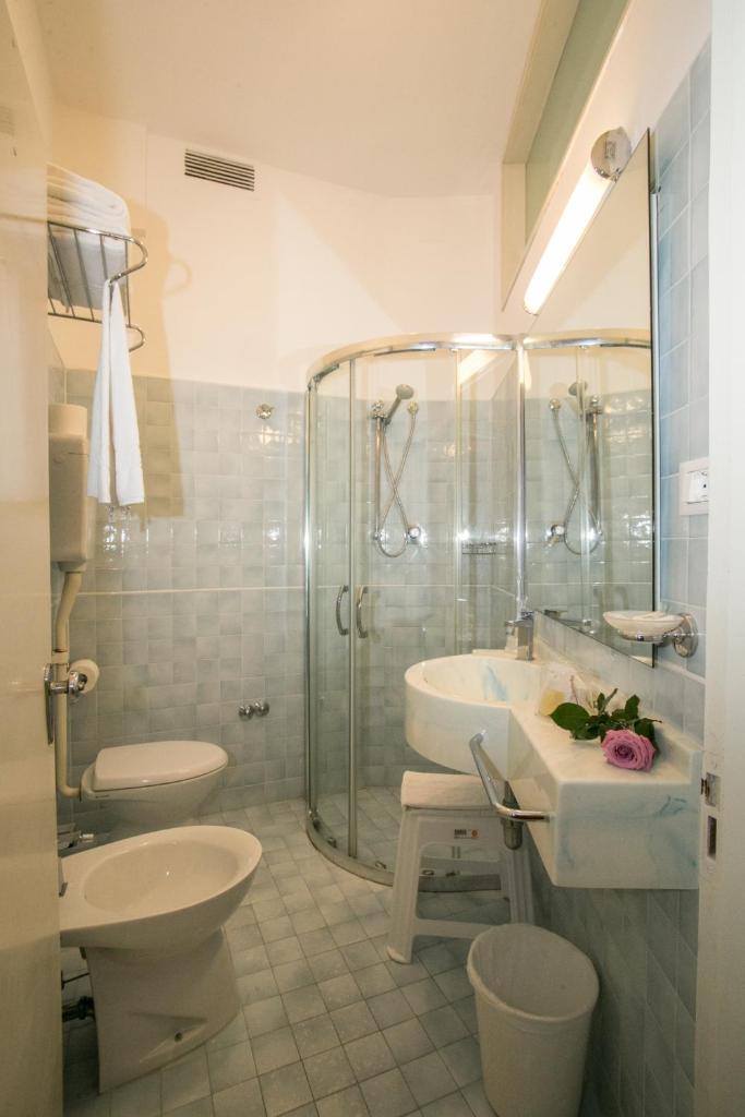 une salle de bain avec douche, lavabo et toilettes dans l'établissement Hotel Caesar, à Rimini