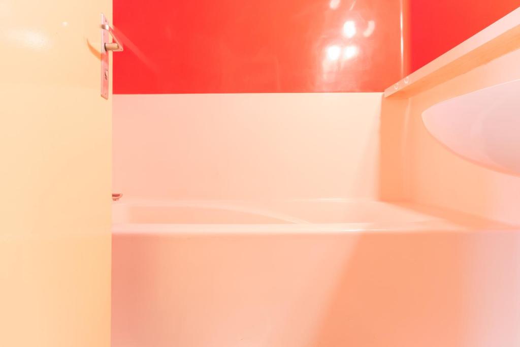 La salle de bains est pourvue d'un mur rouge et blanc. dans l'établissement Studio Belles Challes, à Arc 1800 33 autres photos