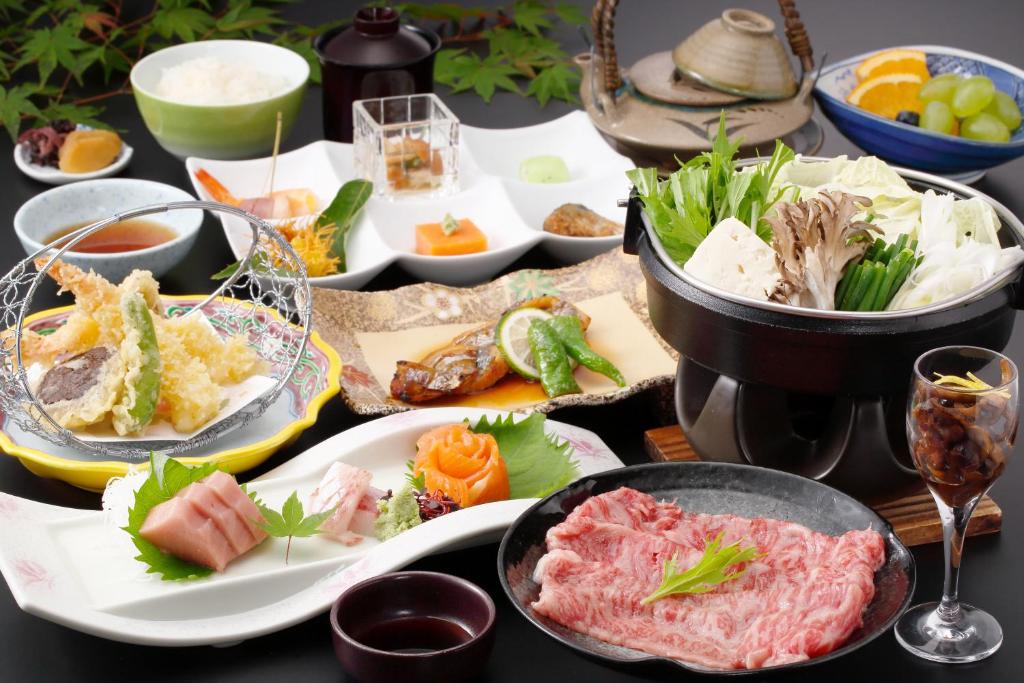 une table avec de nombreuses assiettes de nourriture dessus dans l'établissement Tamamine Sanso, à Okuizumo-cho 11 autres photos