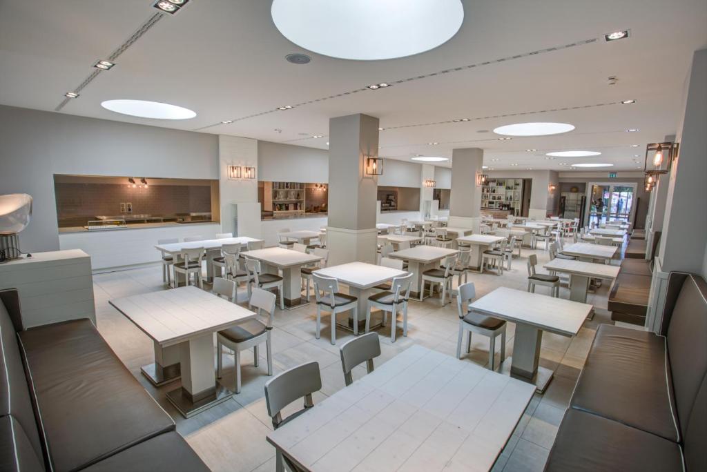un restaurant avec des tables et des chaises dans une cafétéria dans l'établissement Hotel Europa Monetti, à Cattolica