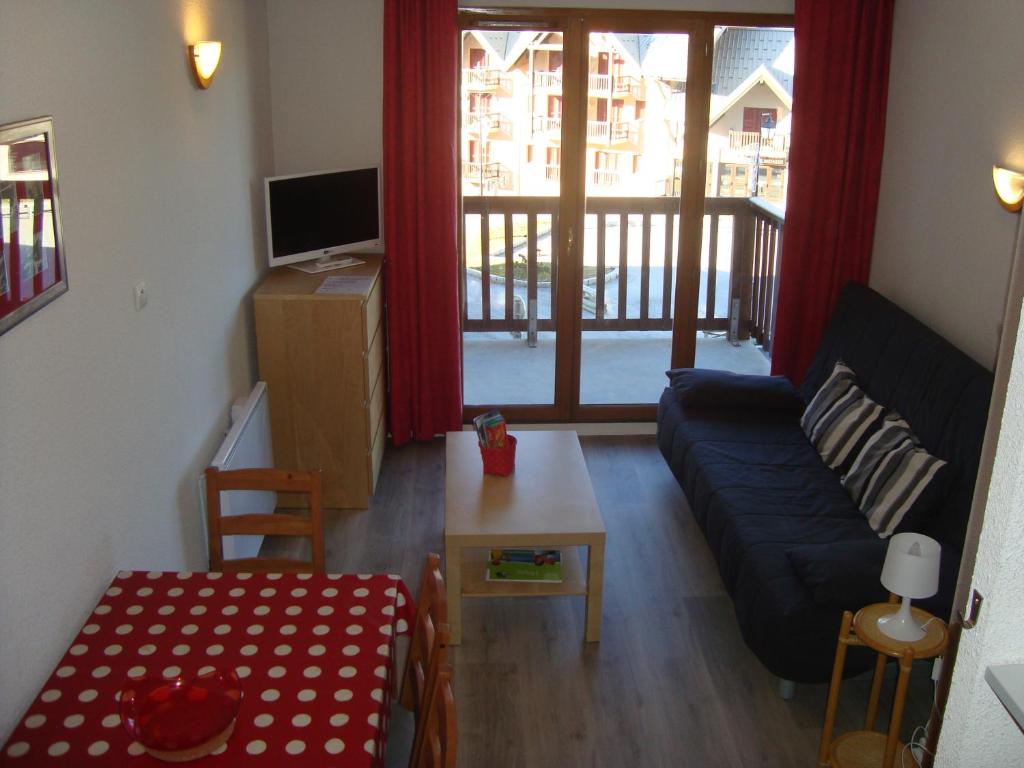 un salon avec un canapé et une table dans l'établissement Les Hauts Valmeinier, à Valmeinier