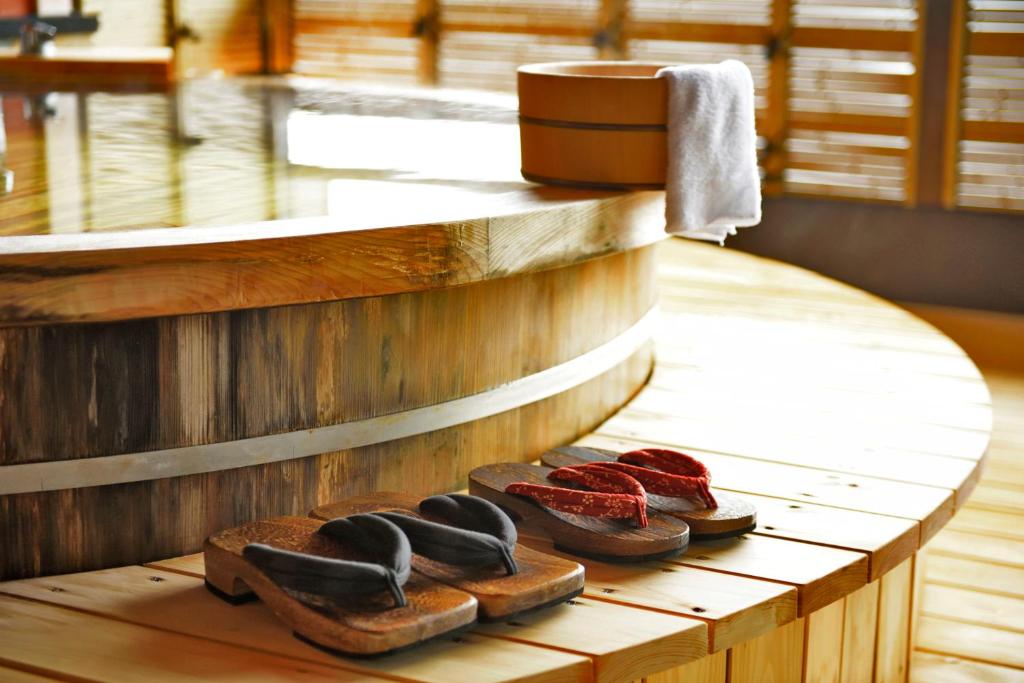 une rangée de chaussures assise sur un banc en bois dans l'établissement Shin Kaikatei Izumi, à Izu