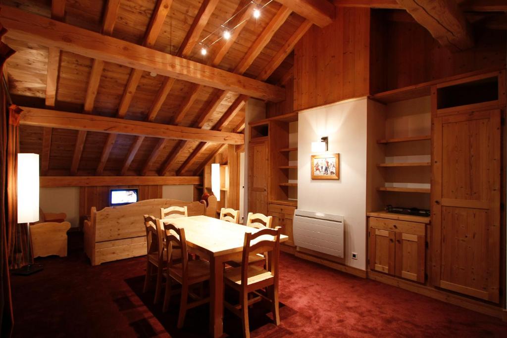 une salle à manger avec une table et des chaises et une chambre dans l'établissement Vacanceole - Résidence Goléon -Val Ecrins, à Les Deux Alpes