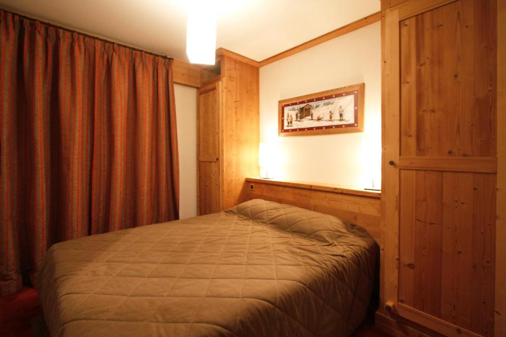 une chambre avec un lit dans une pièce avec une fenêtre dans l'établissement Vacanceole - Résidence Goléon -Val Ecrins, à Les Deux Alpes