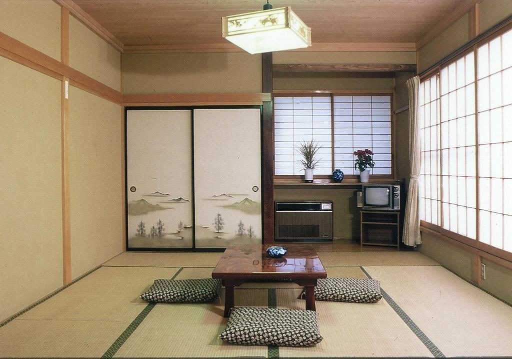 une pièce avec une table dans une pièce avec des fenêtres dans l'établissement Takanoya, à Yuzawa