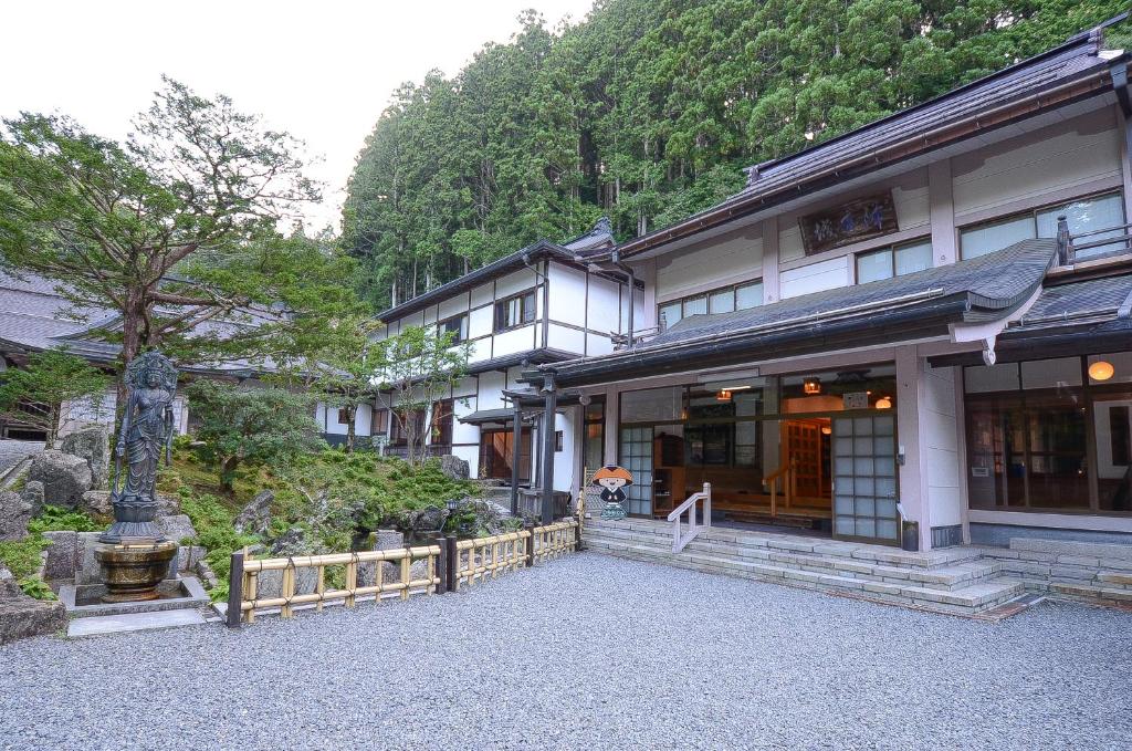 un bâtiment avec un arbre devant lui dans l'établissement 高野山 宿坊 不動院 -Koyasan Shukubo Fudoin-, à Koyasan