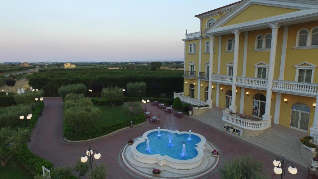 un grand bâtiment jaune avec un gâteau devant dans l'établissement Hotel Villa Santa Maria, à Villapiana