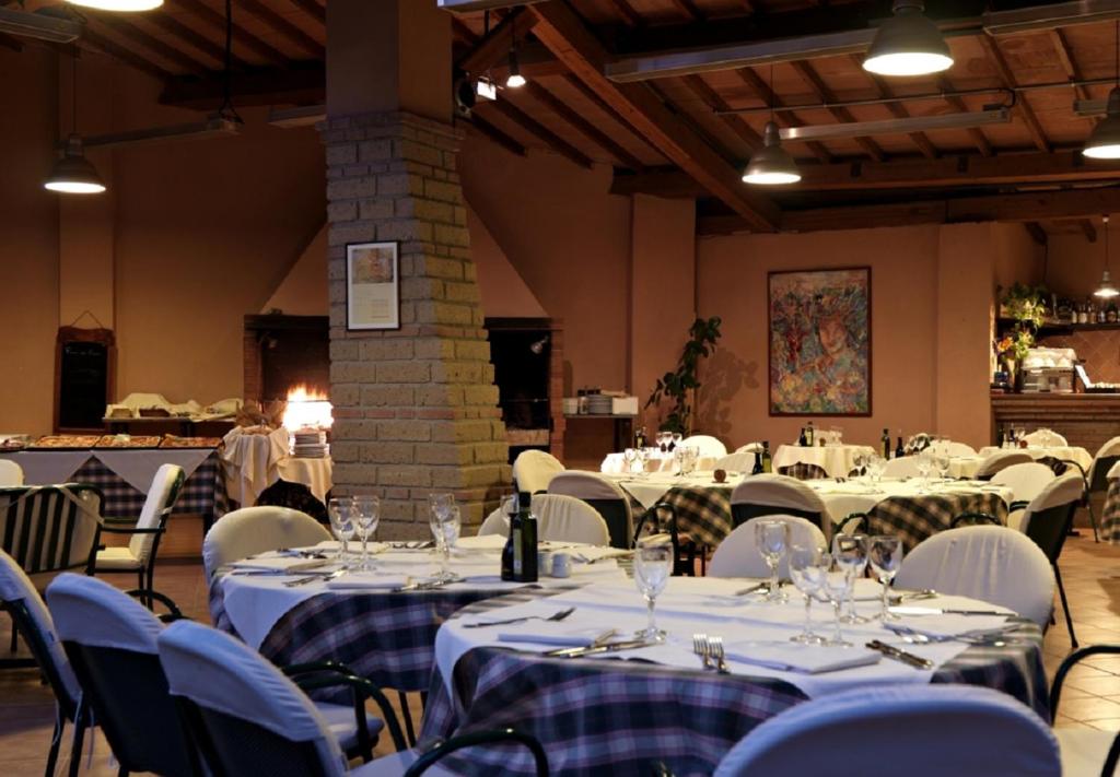 une salle de banquet avec des tables et des chaises blanches dans l'établissement Montebelli Agriturismo & Country Hotel, à Caldana