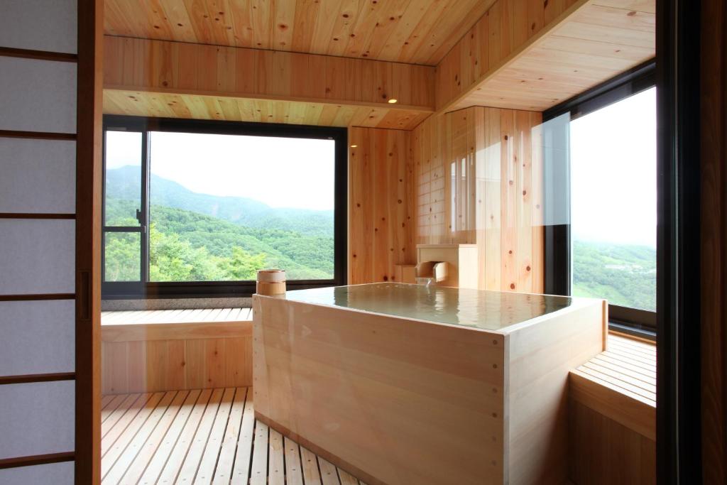 Cette chambre dispose d'une grande fenêtre et d'une grande baignoire. dans l'établissement Hotel Higashidate, à Yamanouchi
