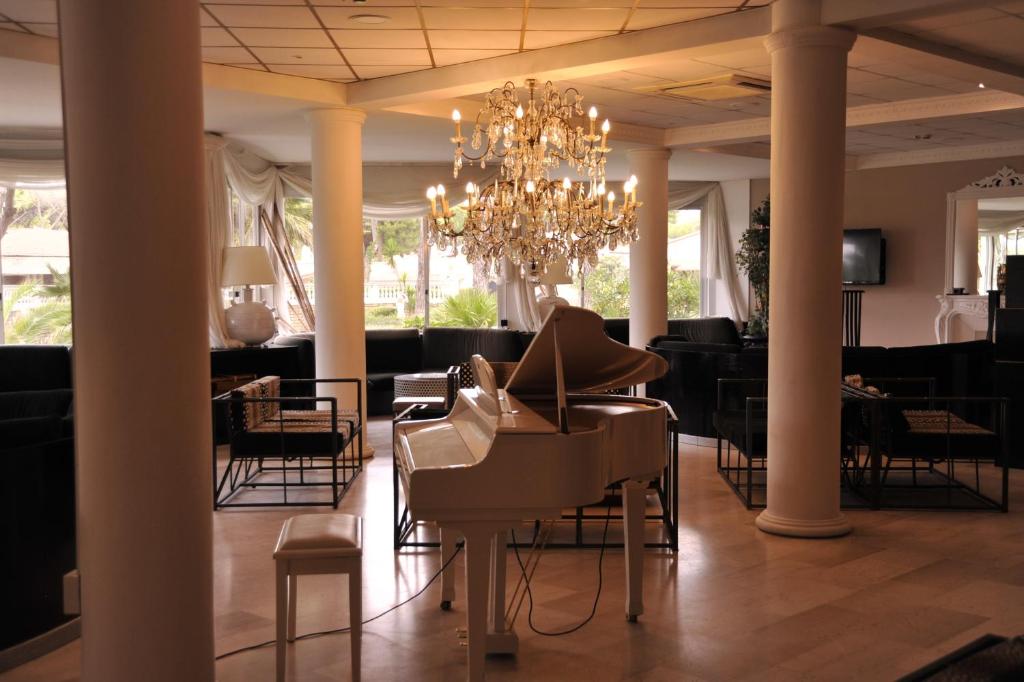 - un hall avec un lustre, des tables et des chaises dans l'établissement Domizia Palace Hotel, à Baia Domizia