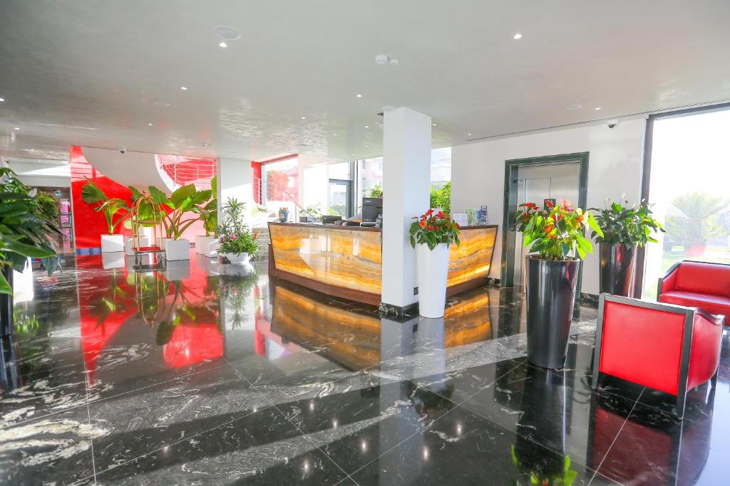 un hall d'entrée avec des plantes en pot dans un immeuble dans l'établissement Victoria Palace Cefalù, à Cefalù