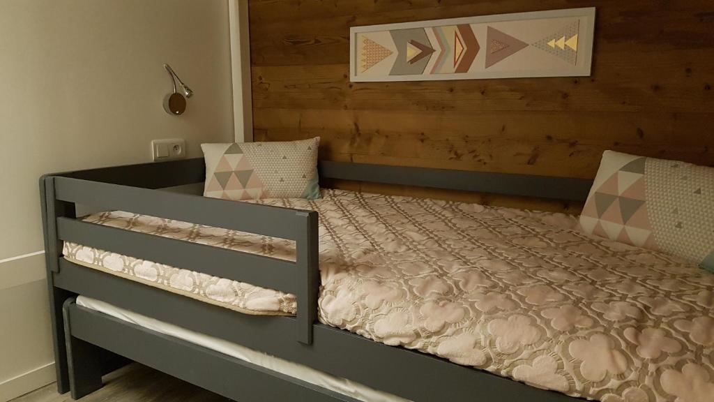 une chambre avec un lit avec une tête de lit en bois dans l'établissement Carene - Belle plagne - 8 personnes, à Belle Plagne