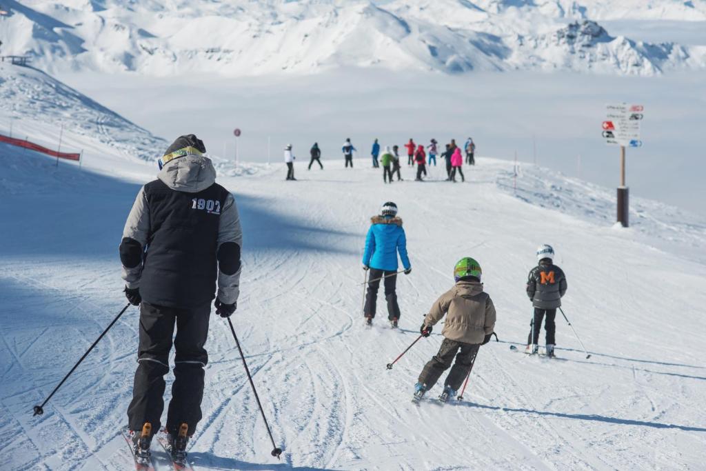 un groupe de personnes à skis dans la neige dans l'établissement Les Carlines, à Vars