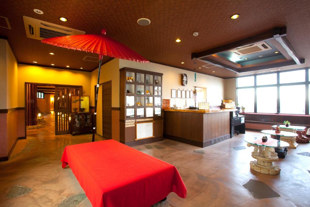 une chambre avec une table rouge et un parapluie rouge dans l'établissement Hamazen Ryokan, à Hinagu