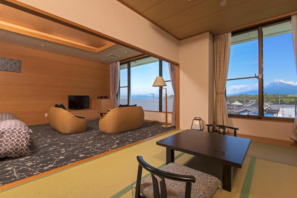 une chambre d'hôtel avec un lit, un bureau et des chaises dans l'établissement KKR Numazu Hamayu, à Numazu