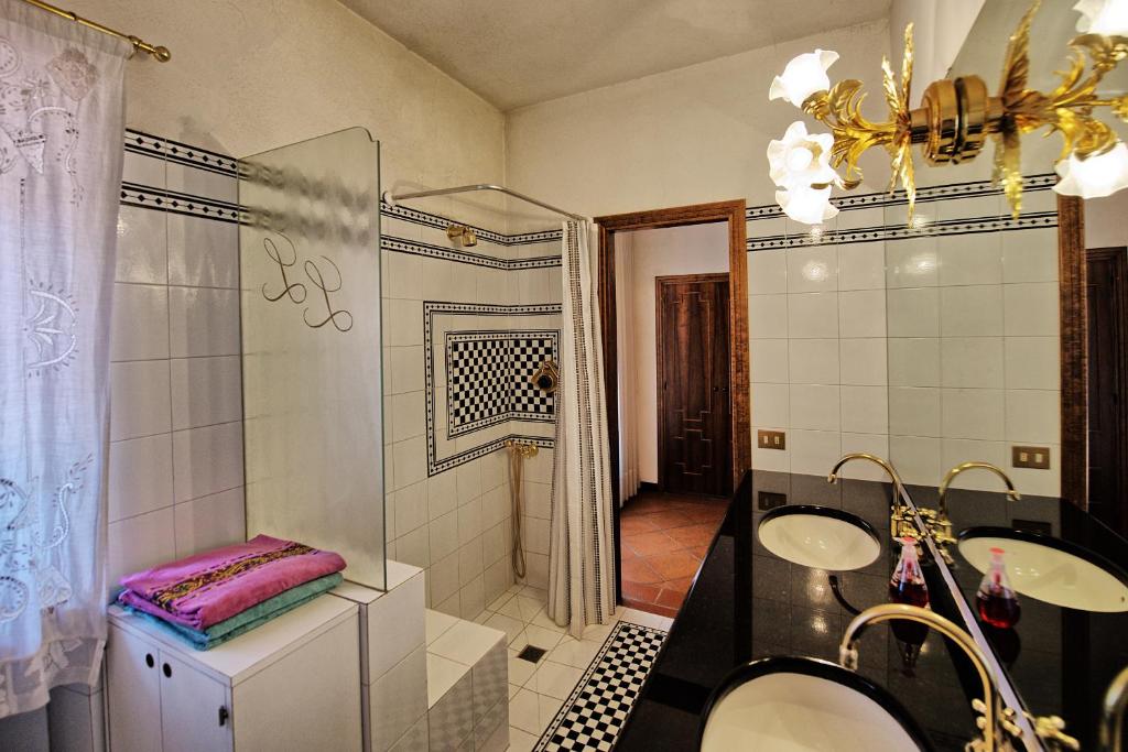 une salle de bain avec deux lavabos et une douche en verre dans l'établissement Villa Lorena by PosarelliVillas, à Pieve San Giovanni