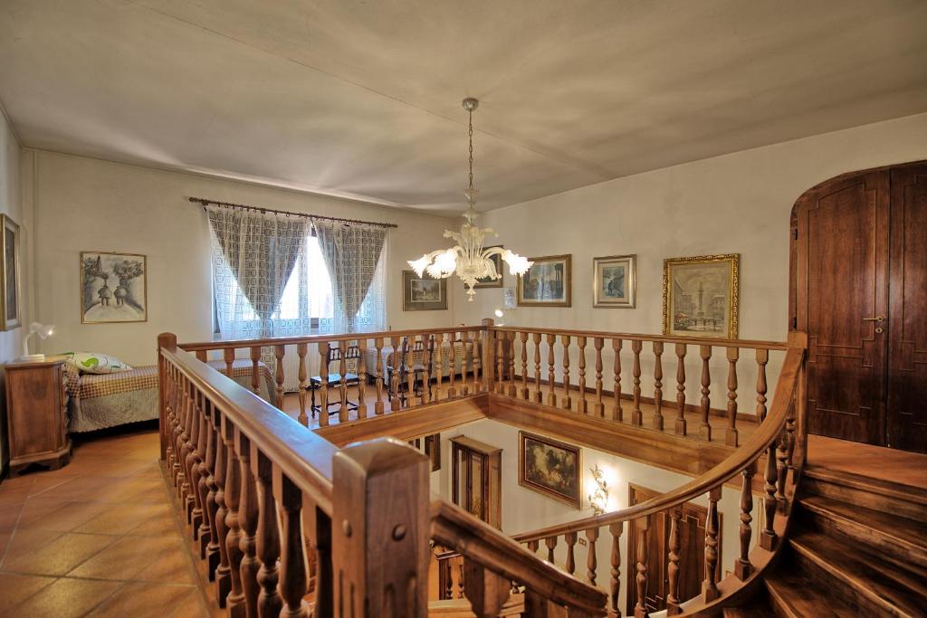 un escalier en bois dans un salon avec un lustre dans l'établissement Villa Lorena by PosarelliVillas, à Pieve San Giovanni