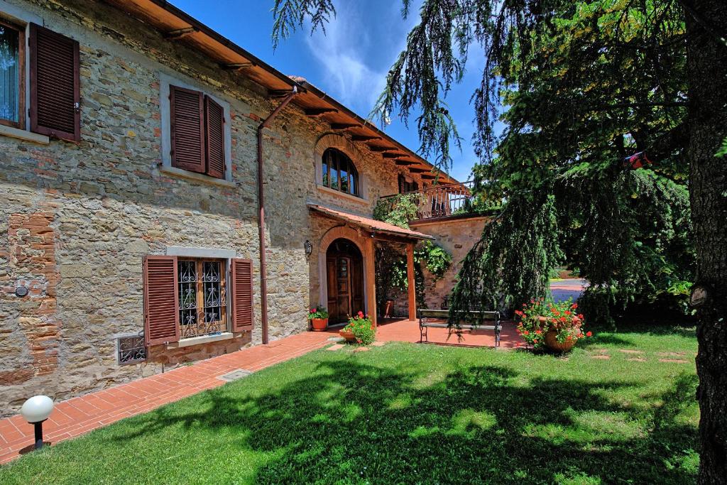 une maison dotée d'une cour avec un banc devant elle dans l'établissement Villa Lorena by PosarelliVillas, à Pieve San Giovanni