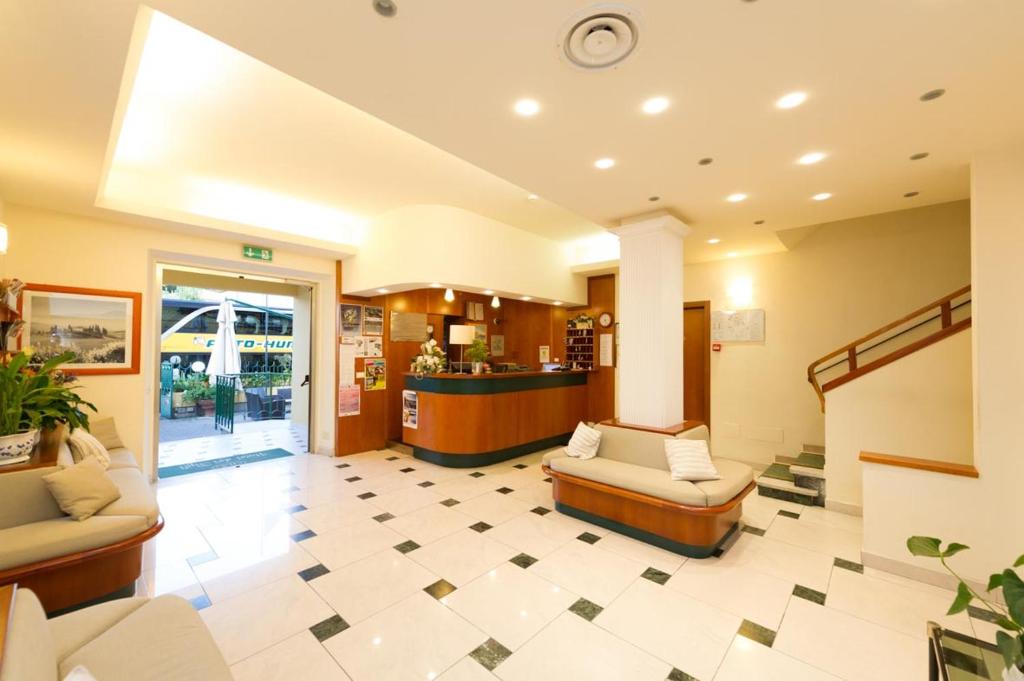 un hall d'entrée avec des canapés et un comptoir dans un hôpital dans l'établissement Hotel Dei Tigli, à Lido di Camaiore
