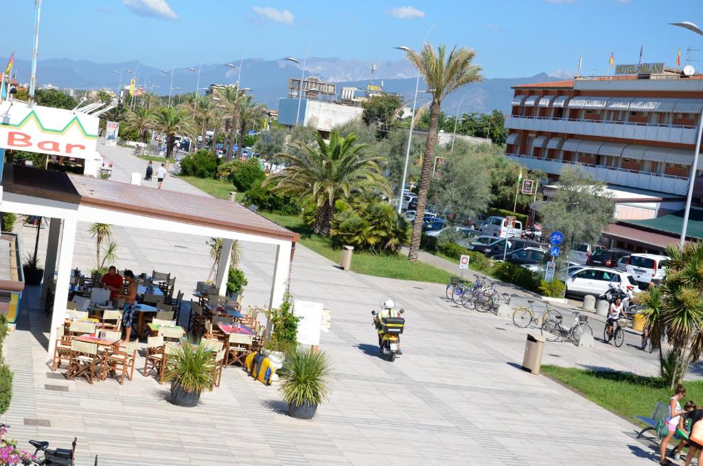 une rue avec des tables et des chaises sur un trottoir dans l'établissement Hotel Biagiotti, à Lido di Camaiore