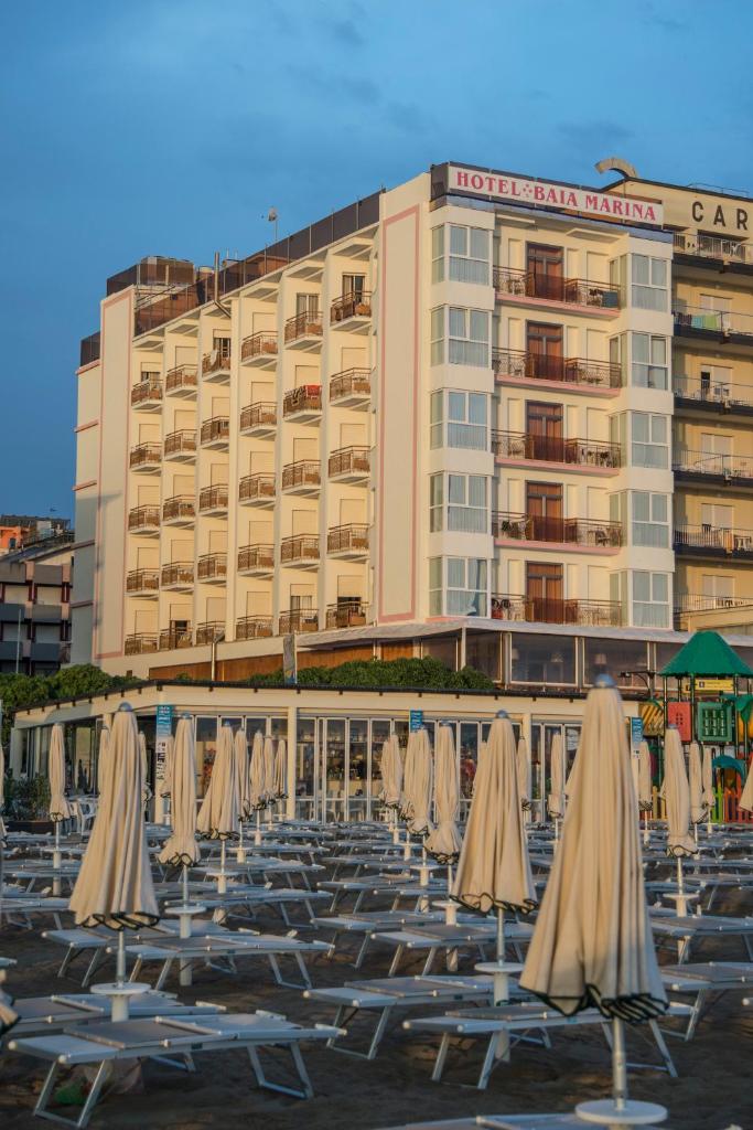une rangée de chaises de jardin devant un hôtel dans l'établissement Hotel Baia Marina, à Cattolica