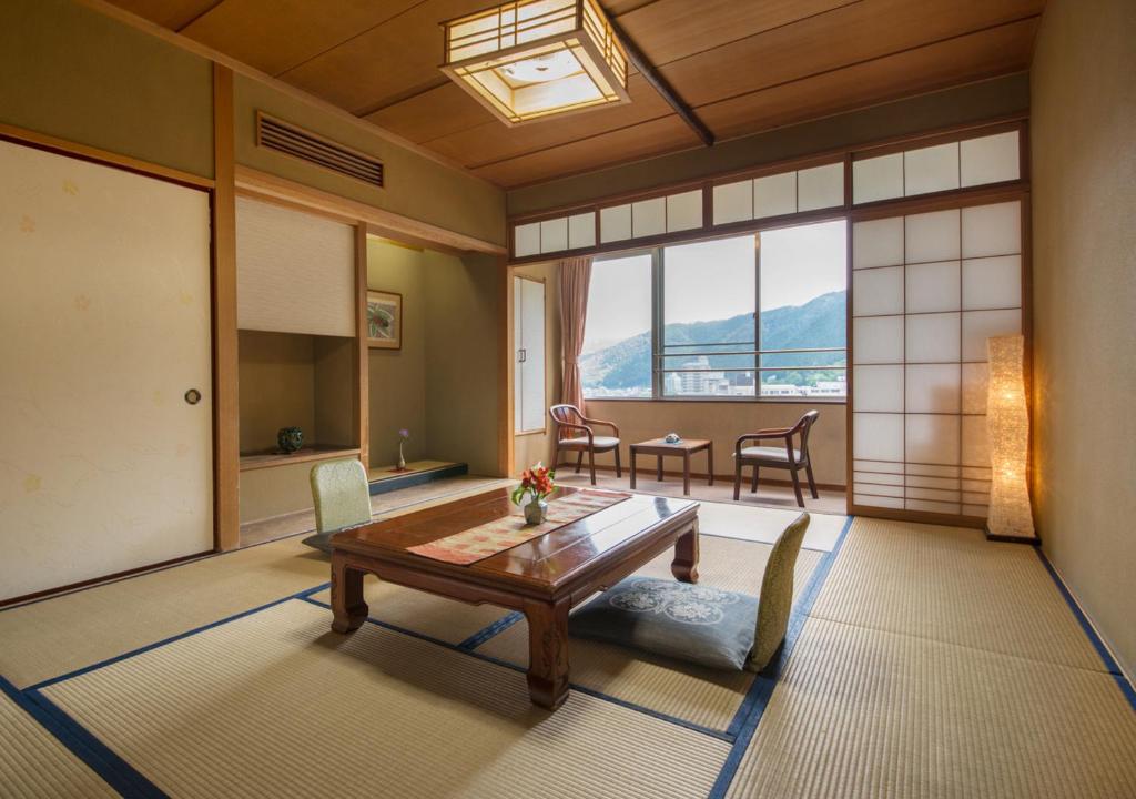 un salon avec une table et des chaises et une fenêtre dans l'établissement Yamagataya, à Gero