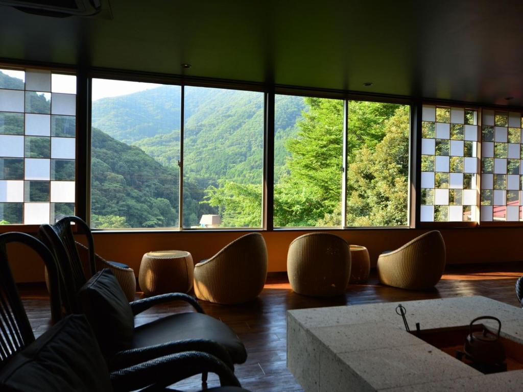 une chambre avec vue sur une montagne à travers les fenêtres dans l'établissement Hatago Kintoen, à Hakone