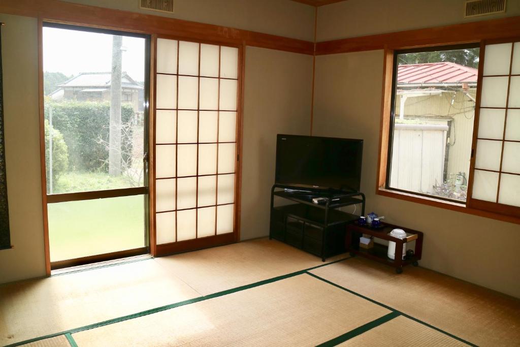une pièce vide avec télévision et fenêtres dans l'établissement Hotel Otani, à Chiba
