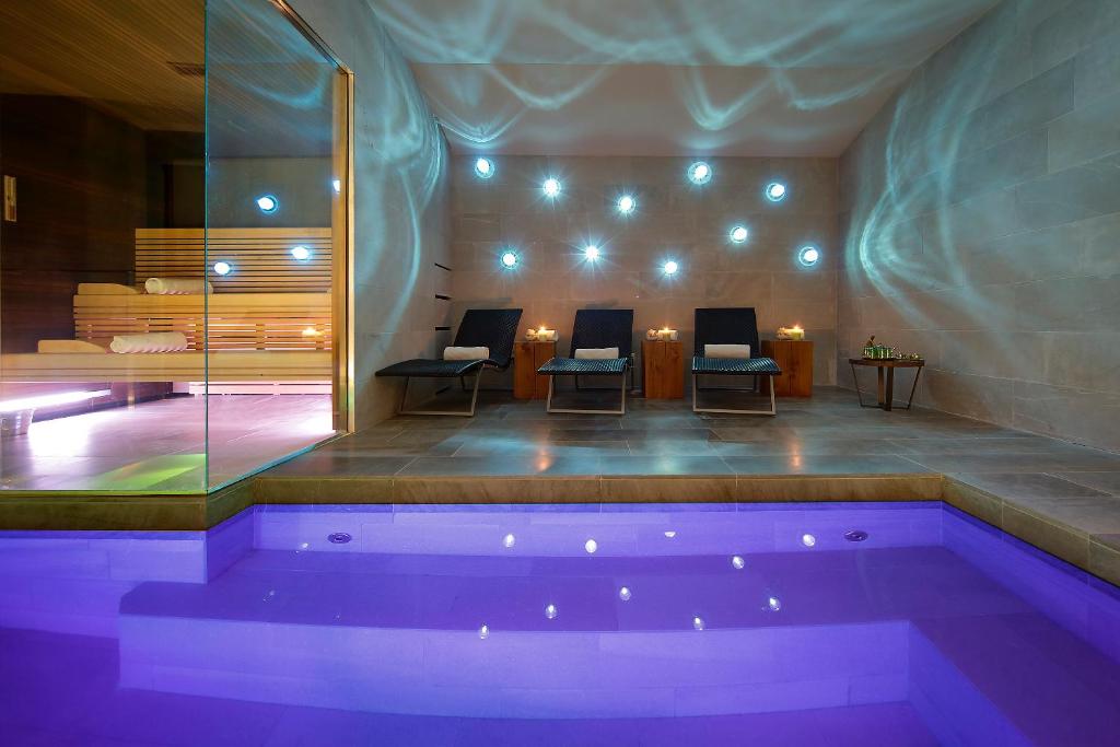 - une piscine dans une pièce avec des chaises et une table dans l'établissement Grand Hotel Campione, à Campione dʼItalia