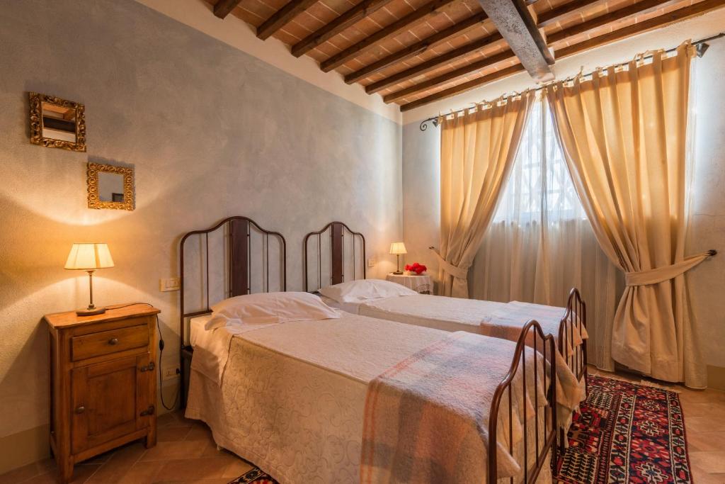 une chambre avec deux lits et une fenêtre dans l'établissement Anticopozzo by VacaVilla, à Monsanto