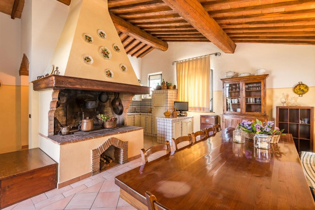 - un salon avec une cheminée, une table et des chaises dans l'établissement Anticopozzo by VacaVilla, à Monsanto