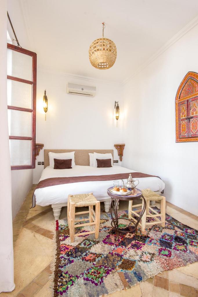 une chambre avec un grand lit et une table dans l'établissement Riad Amira, à Marrakech